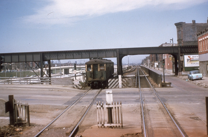 #16 - An eastbound 4000-series train is on Van Buren Street at Paulina. The 4000s represented the middle years of the street level operation, bridging wood cars (early) and 6000s (later). The new structure for Douglas trains is behind the facing train. Paulina's streetcar tracks are no longer evident. Answer: CTA 4446 at Van Buren/Paulina on April 21, 1957. (Photo by Ray DeGroote)