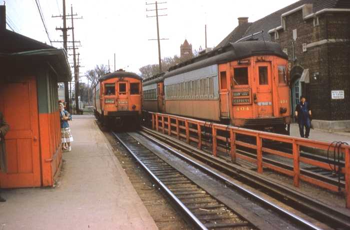 #3 - An almost timeless photo of CA&E 457 and 404 at Wheaton station, the hub of CA&E operations. The woman's babushka suggests late spring or early fall. The key clue to time would be knowing when 404 received the final paint job and, of course, no later than July 3, 1957. Answer: CA&E 457 at Wheaton on April 21, 1957. (Photo by Ray DeGroote)