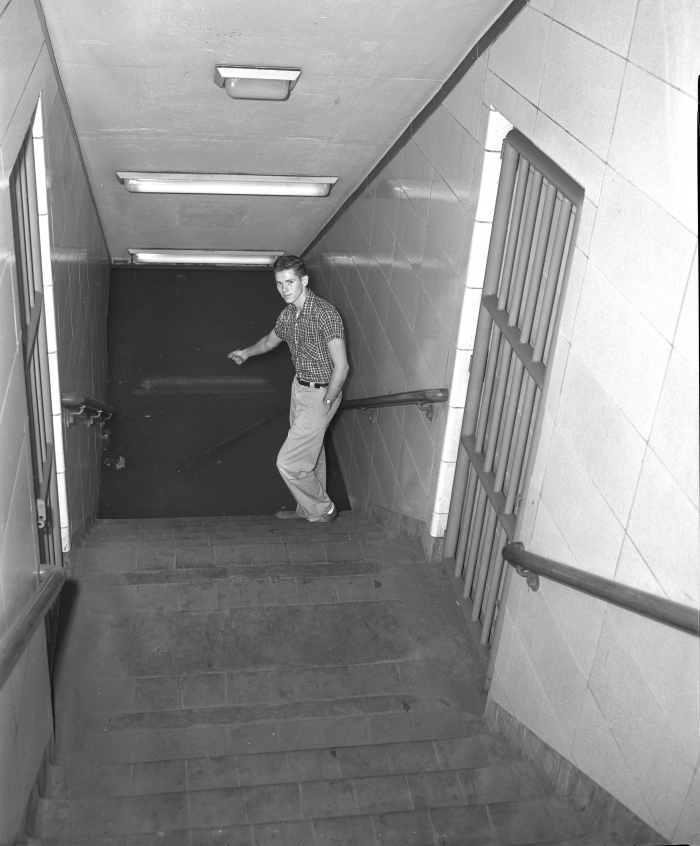 Dennis Headley, CTA ticket agent, points to the flooded subway at the LaSalle and Congress station on July 13, 1957. (Editor's collection)
