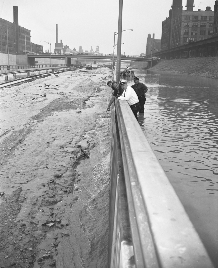 Ist Division Fire Marshall Frank Tokars and a crew of firemen survey the pumping project on the Congress expressway at Halsted. Water was overflowing from the expressway in the CTA section where the "L" trains would tie in with the subway the following year. (Editor's collection)