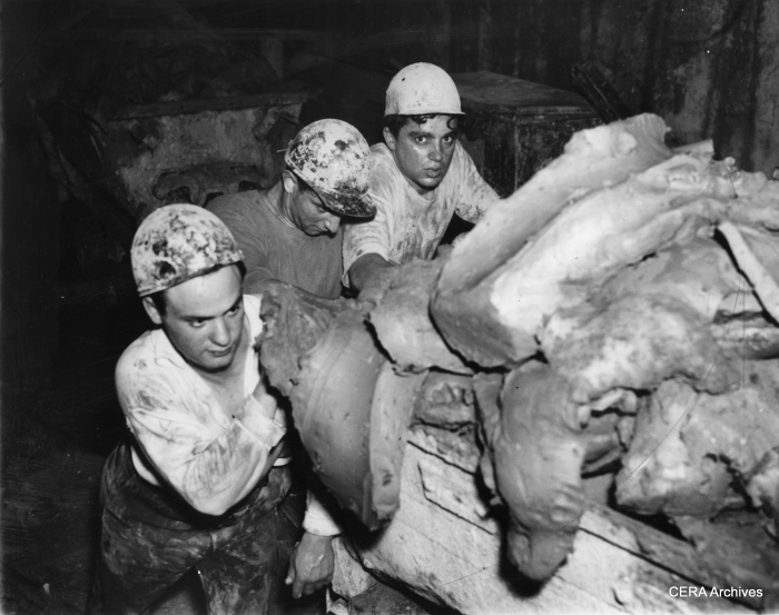 May 31, 1939 - "Muckers" push a load of blue clay after stripping it from the walls of Chicago's future subway.