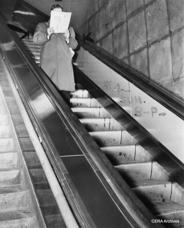 A Chicago subway scene on December 23, 1943. "Escalator all to himself, post-midnight customer reads while he rides. No din, no shove."
