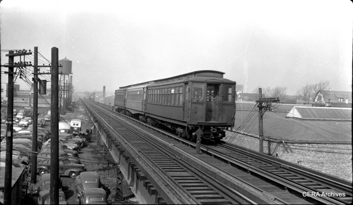 In the early 1950s, a westbound Garfield Park train descends the ramp between the Cicero and Laramie stations.