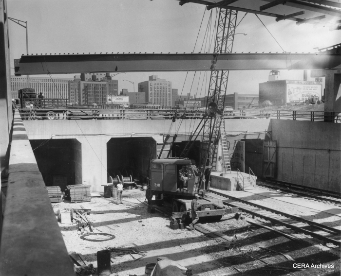 June 10, 1958 - 'Pictorially, you are "entering" Chicago's new CTA subway which will open June 22. The subway proper runs under the Congress Expressway from Halsted to link with the Dearborn-Milwaukee subway at Dearborn. Trains will enter the subway from an open cut in the expressway, on which they will travel from Lockwood (5300 west). Ultimately the western terminal of the expressway run will be at Desplaines av., Forest Park. From Lockwood to Dearborn, the trains will take just 14 minutes. The scene here is looking east from Halsted at the start of the subway proper. A crane hoists a beam into place for auto traffic interchange at this point." (Photographer unknown)