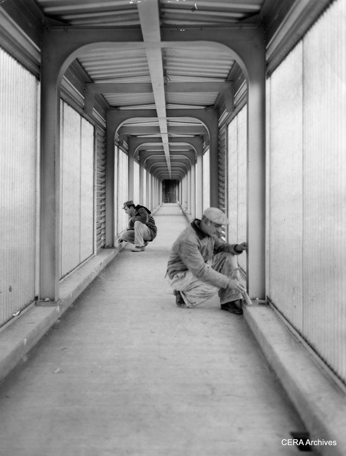 December 9, 1957 - "Congress Expy. and Cicero: Dale Mueller, tile setters' helper and Tom Shue, tile setter, work on the inside of the ramp that leads to station." (Photo by Knefel) The full-length fiberglass panels on these station ramps soon became a problem, since they shielded anyone in the tunnel from view and were considered havens for crime. Eventually they were partially removed.