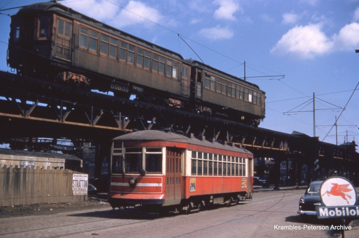 In this classic photo by George Krambles, an "L" train led by car 1753 passes surface car 3136 in April 1952.