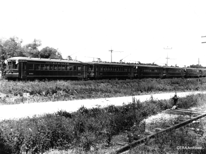 A line of cars headed up by Interstate Public Service car 263. Interstate was one of the predecessor companies to Indiana Railroad. According to Don's Rail Photos, "263 was built by Kuhlman Car Co in 1927, #924. It became IRR 202 in 1930 and sold as Portland Traction Co 4001 in 1940. It was acquired by Northern California Trolley Museum in 1959 and Western Railway Museum in 1960. It was restored as IRR 202." A note on the back of the photo says these cars were used in the Jeffersonville, Charlestown, and New Albany area. (Photographer unknown - CERA Archives)