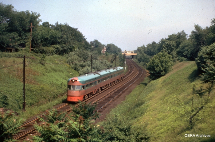 A CNS&M Electroliner speeds through the open cut in Evanston. The former Asbury station is visible in the background. (CERA Archives)